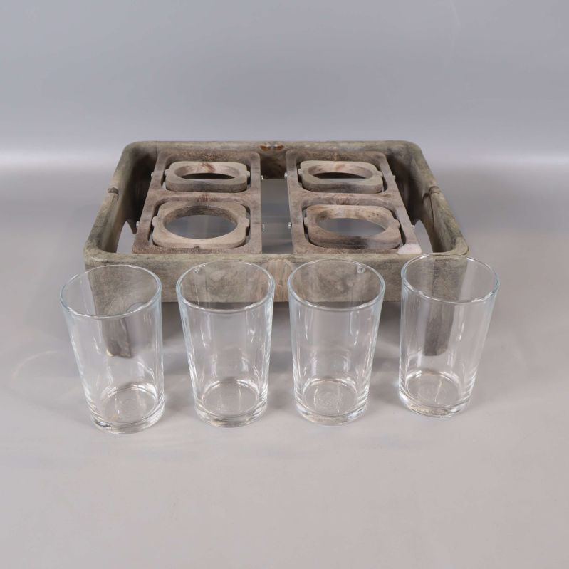 Fyra glas uppställda framför glasbricka i trä