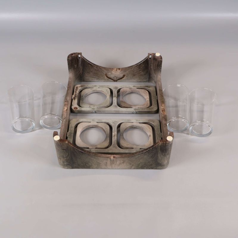 Glasbricka med fyra utskärningar och glas placerade bredvid