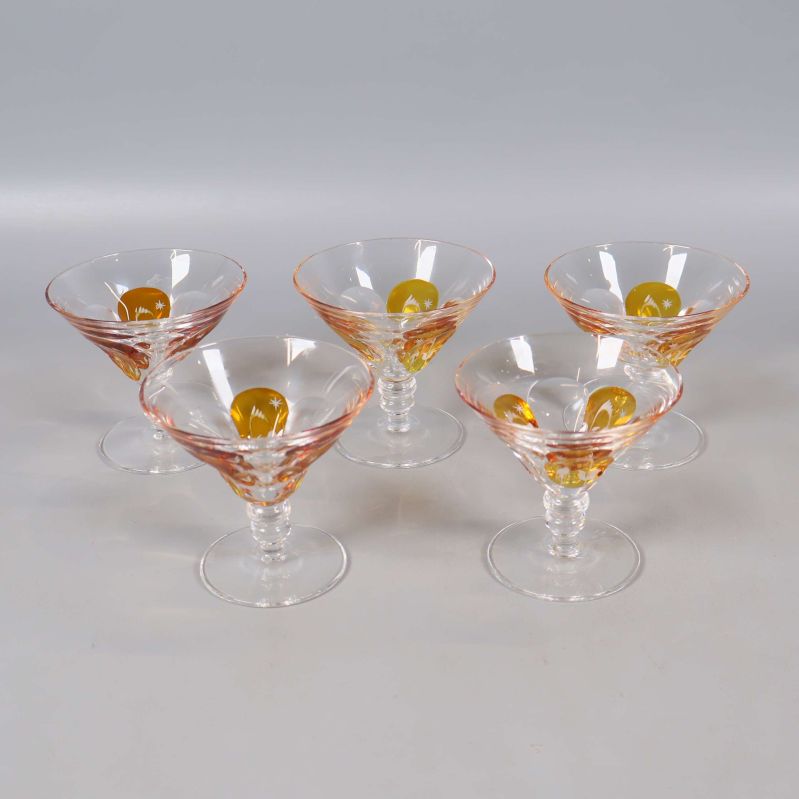 Fem glas på fot med orange dekor på ljus bakgrund