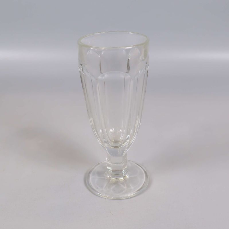 Ett högt glas med räfflad sida och fot