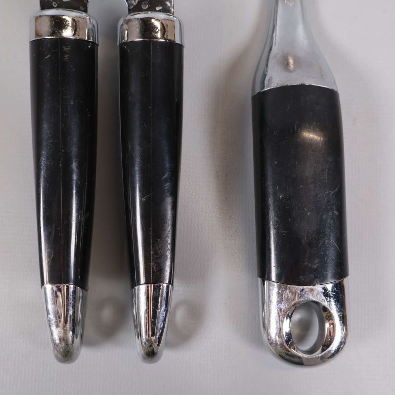 Handtagsdetaljer på båda köksredskapen, svart och metall