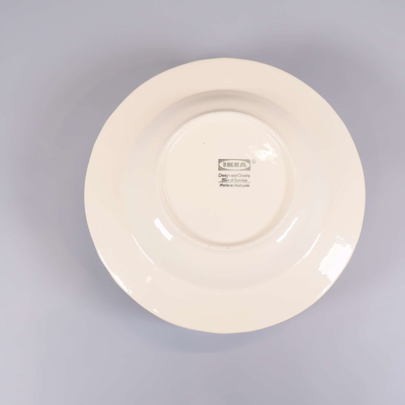 Närbild av IKEA-märkning på tallrikens baksida