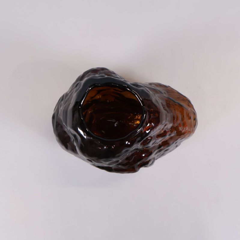 Vy från ovan på mörkbrun glasvas med oval öppning