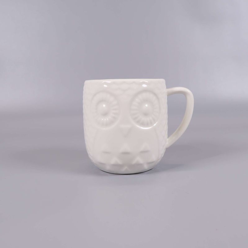 Mugg med ugglemotiv och relief sett snett framifrån