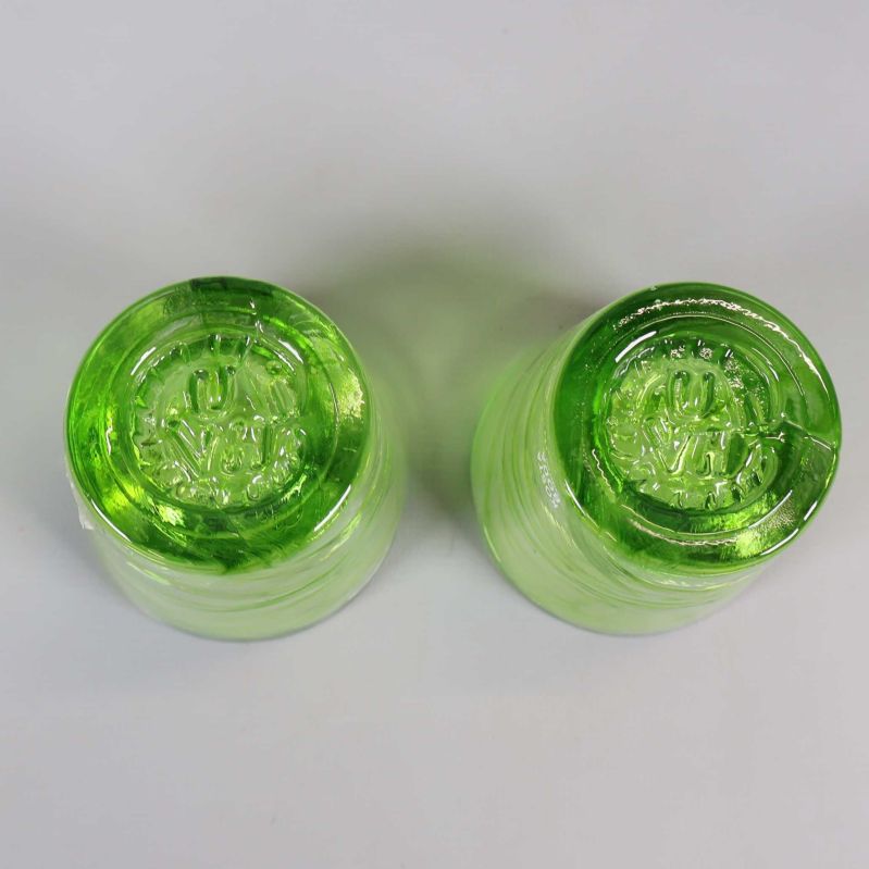 Undersida på två gröna snapsglas med tydlig bottenstruktur