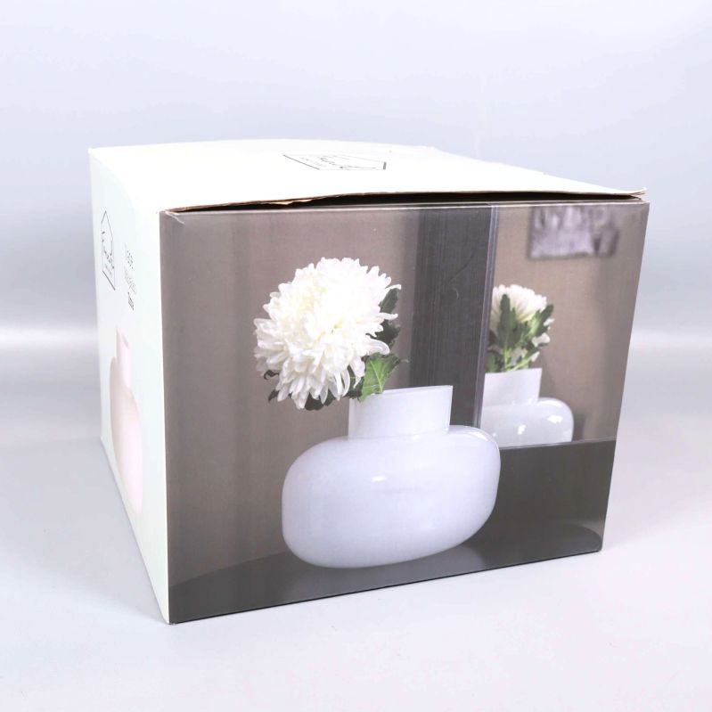 Originalkartong med bild på vas med blomma