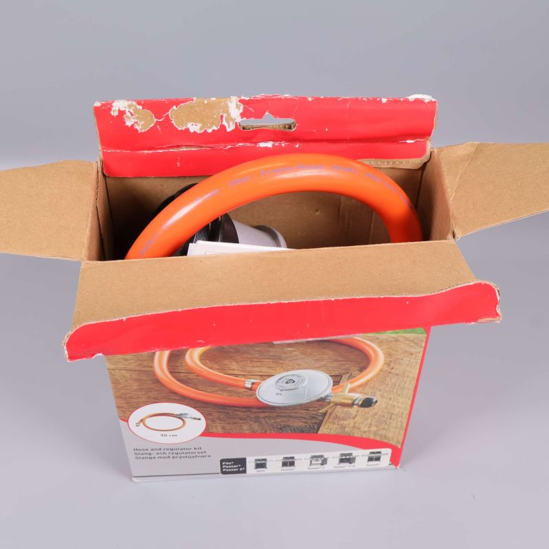 Orange regulatorset placerat i öppnad förpackning