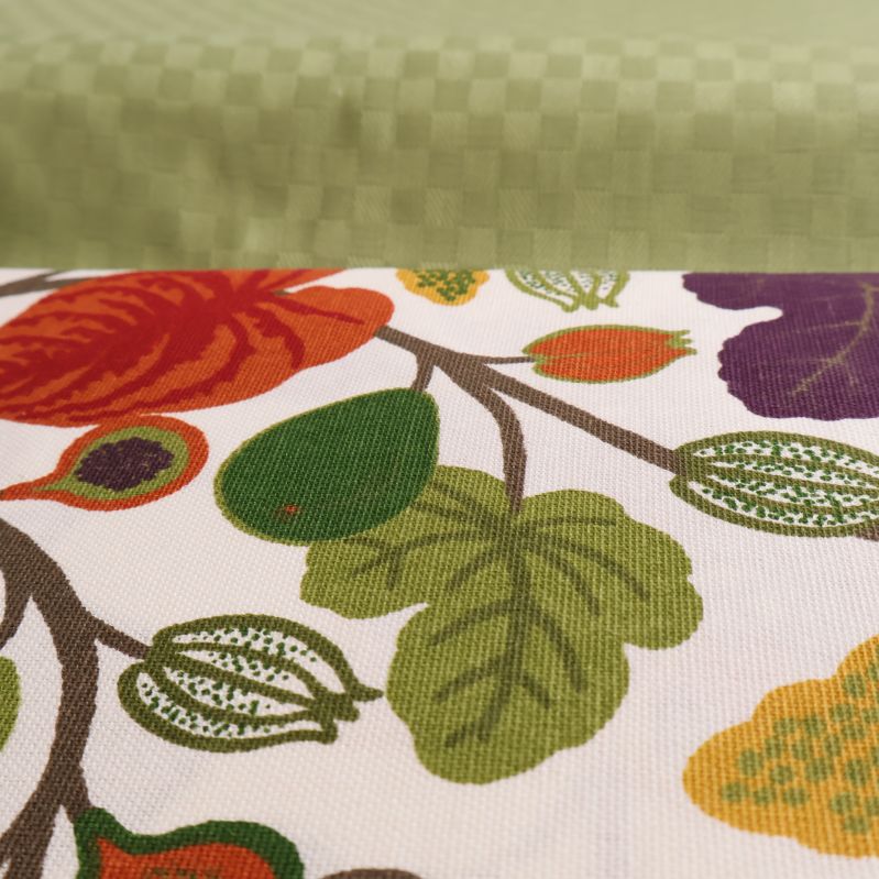 Närbild på textur och mönster av grön och blommig duk