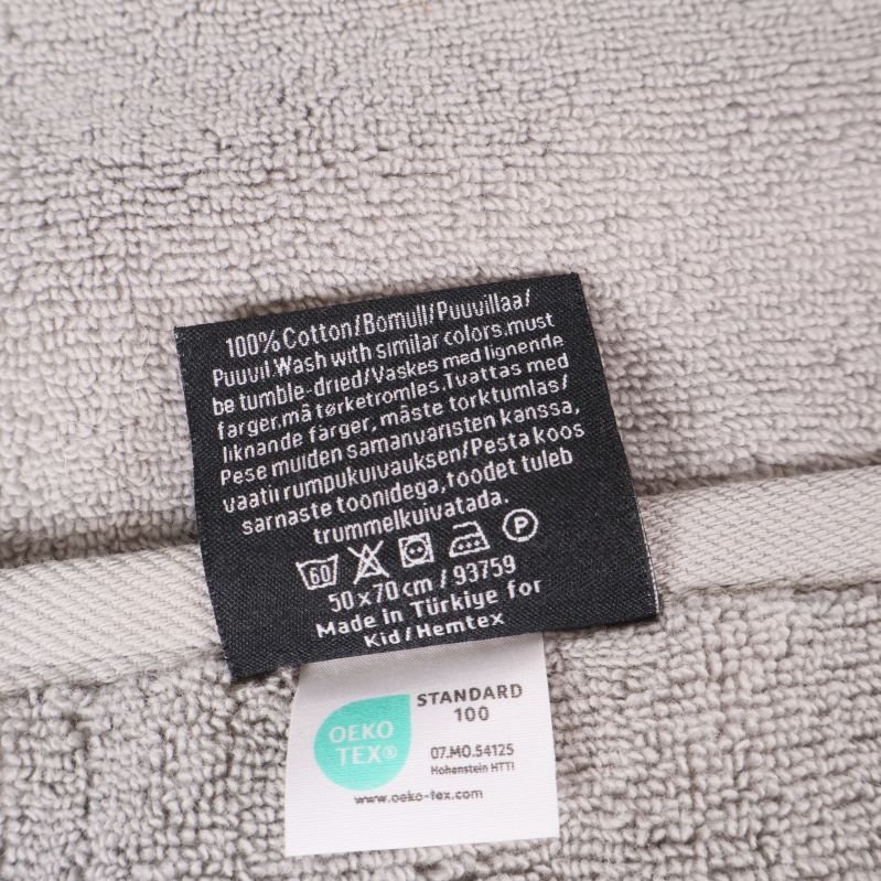Materiallapp visar 100% bomull och skötselinstruktioner