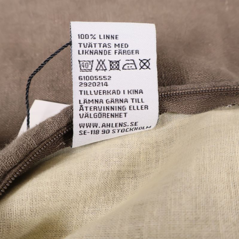 Materialetikett som visar 100% linne på kuddfodral