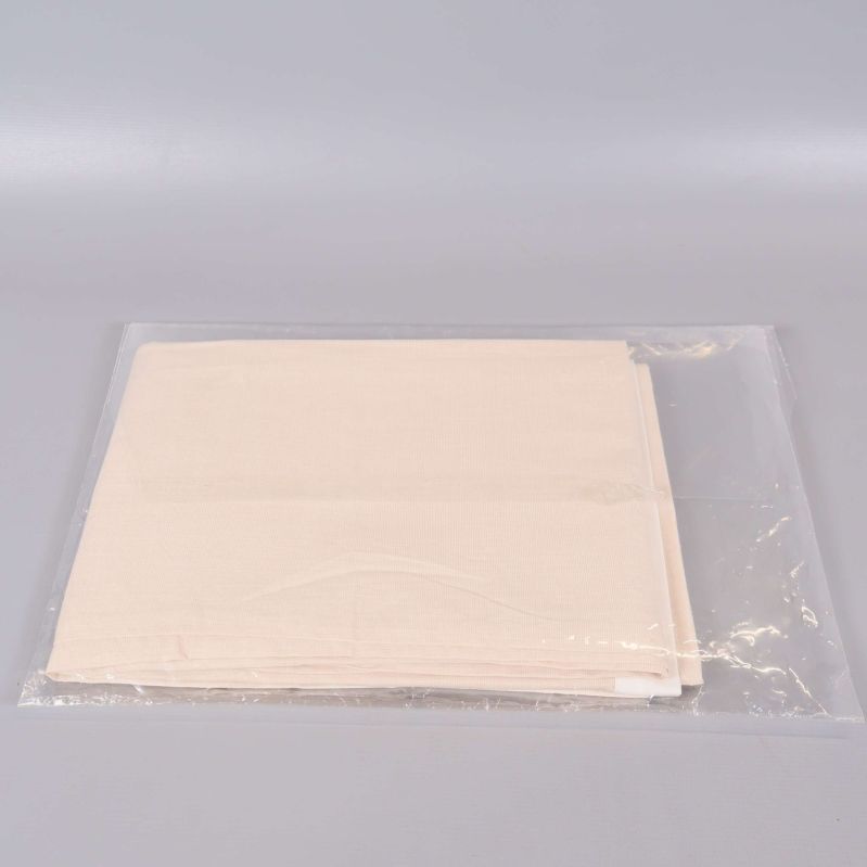 Baksidan av beige örngott i genomskinlig plastpåse