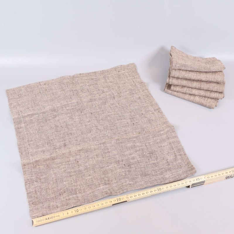 En utvikt beige linneservett med måttstock nedanför