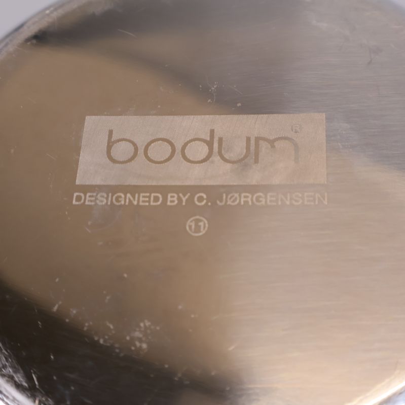 Botten med ingraverad bodum-logotyp och designers namn