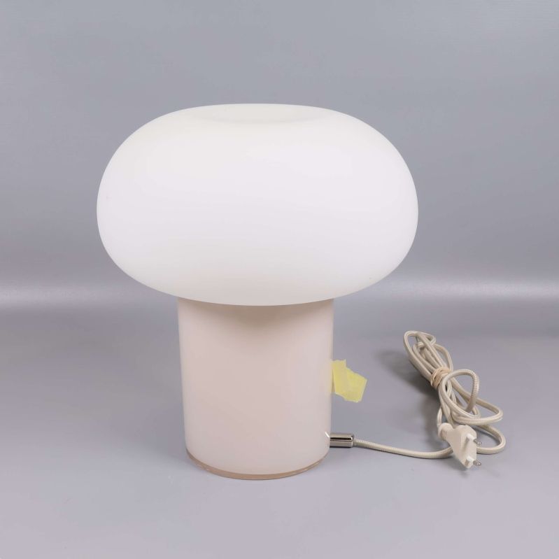 Bordslampa i vitt glas sedd från sidan med sladd