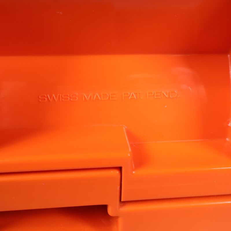 Detalj på orange plast med text Swiss Made Pat Pend