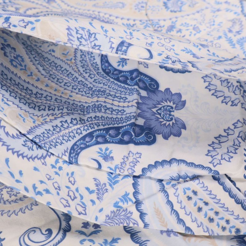 Detaljbild på tyg med blå paisleydesign i bomull