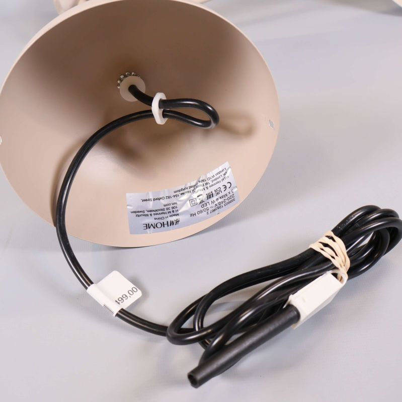 Lampans undersida med svart elkabel och etikett