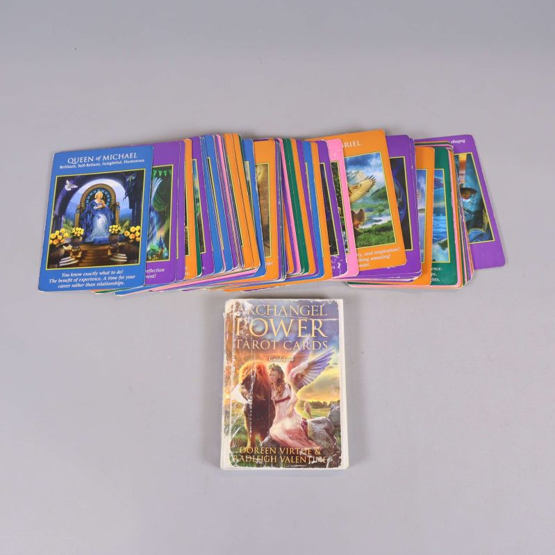 Tarotkort utspridda samt guidebok ovanpå