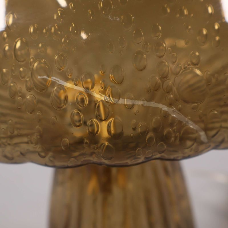 Närbild av glaslampans bubbelformade yta med repa