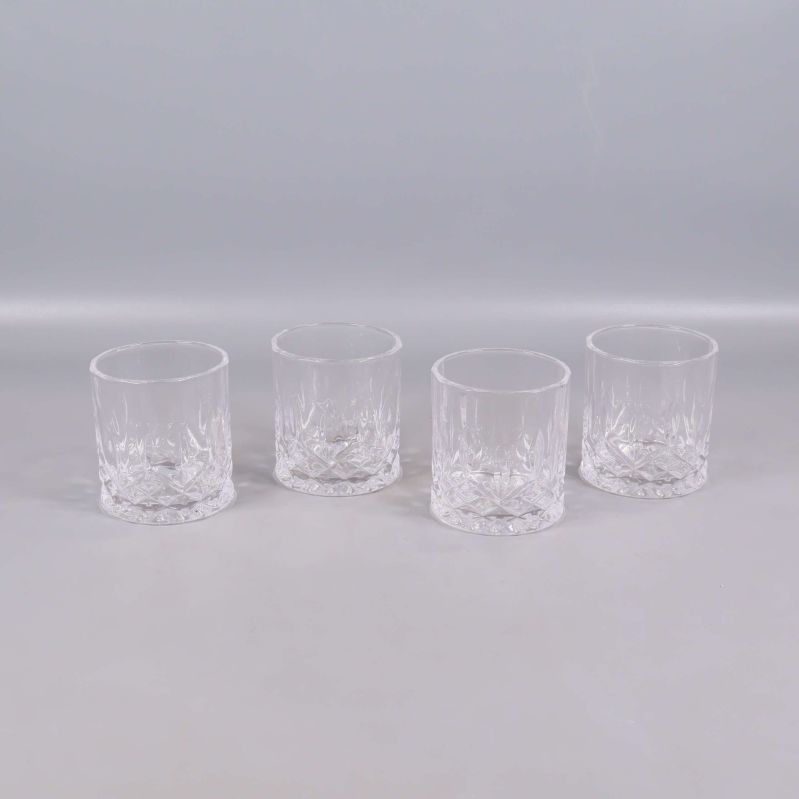 Fyra genomskinliga whiskyglas uppställda i rad