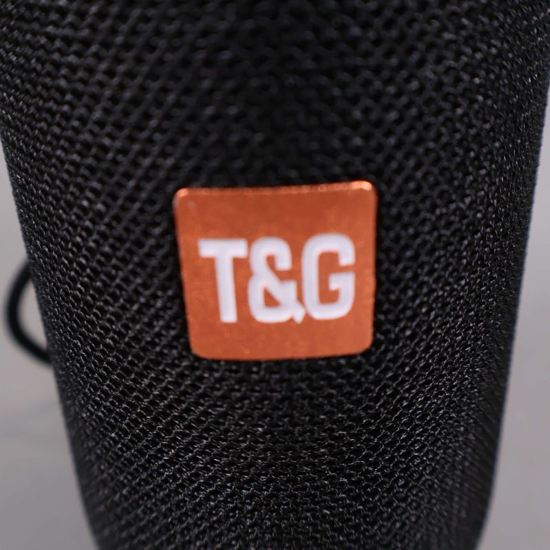 Närbild på T&G-loggan mot högtalarens tyg