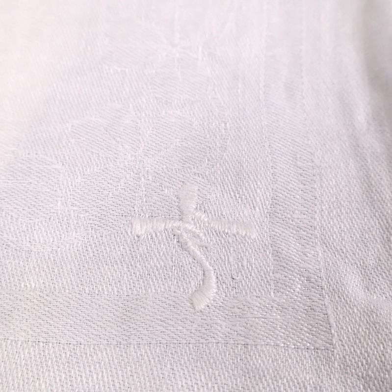 Närbild på broderad detalj i linneduken