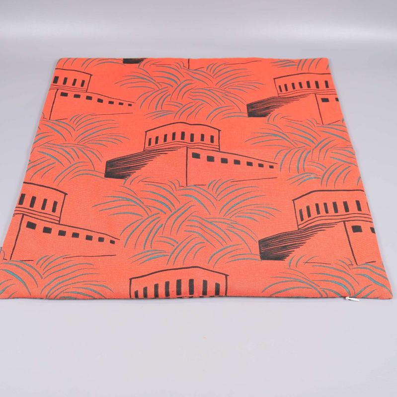 Orange kuddfodral med svart grafiskt motiv och palmblad