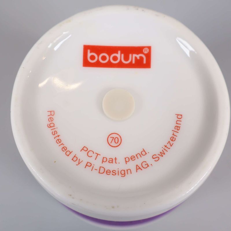 Närbild på botten av mugg med Bodum-logga och text