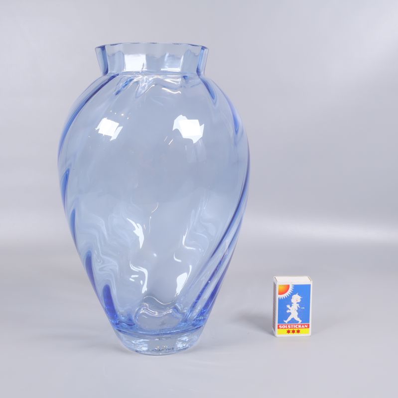 Blå glasvas jämförd med tändsticksask för storlek