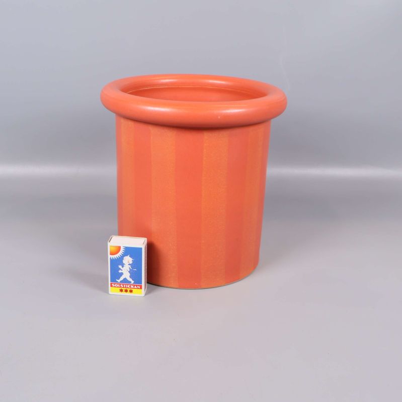Orange ytterkruka och tändsticksask sida vid sida