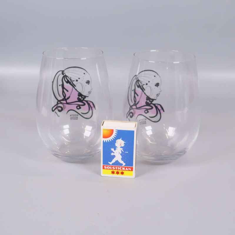 Två glas med motiv bredvid tändsticksask