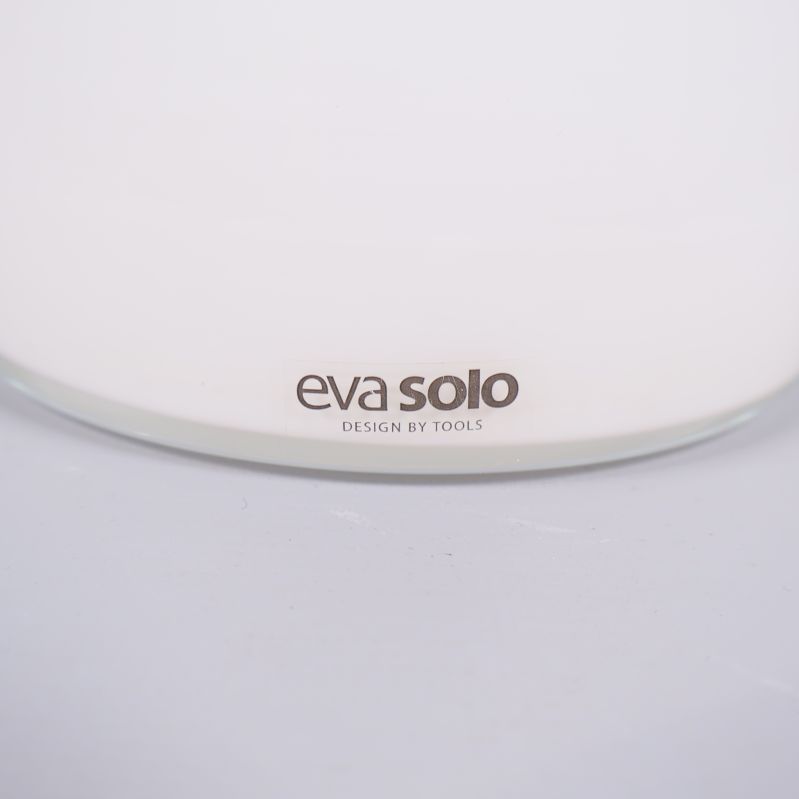 Närbild på Eva Solo-logotyp på vit glasvas