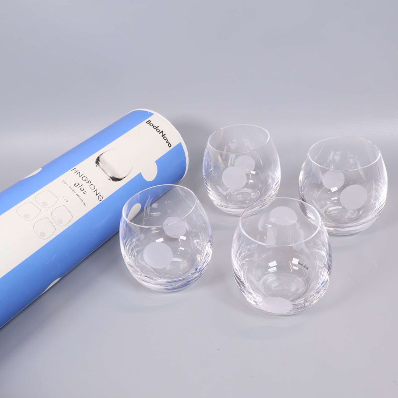 Fyra rundade glas med vita prickar och förpackning
