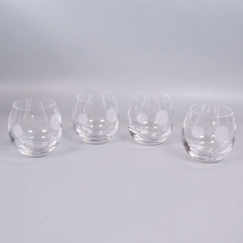 Uppställda glas med vit prickdekor på rad