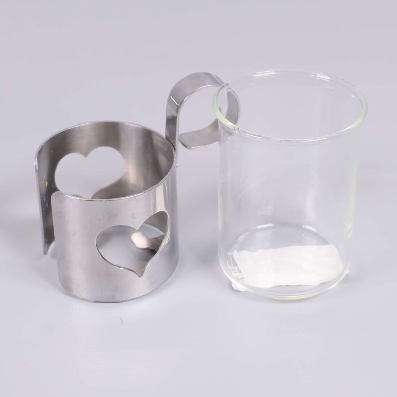 Ett glas bredvid en metallhållare med hjärtmotiv