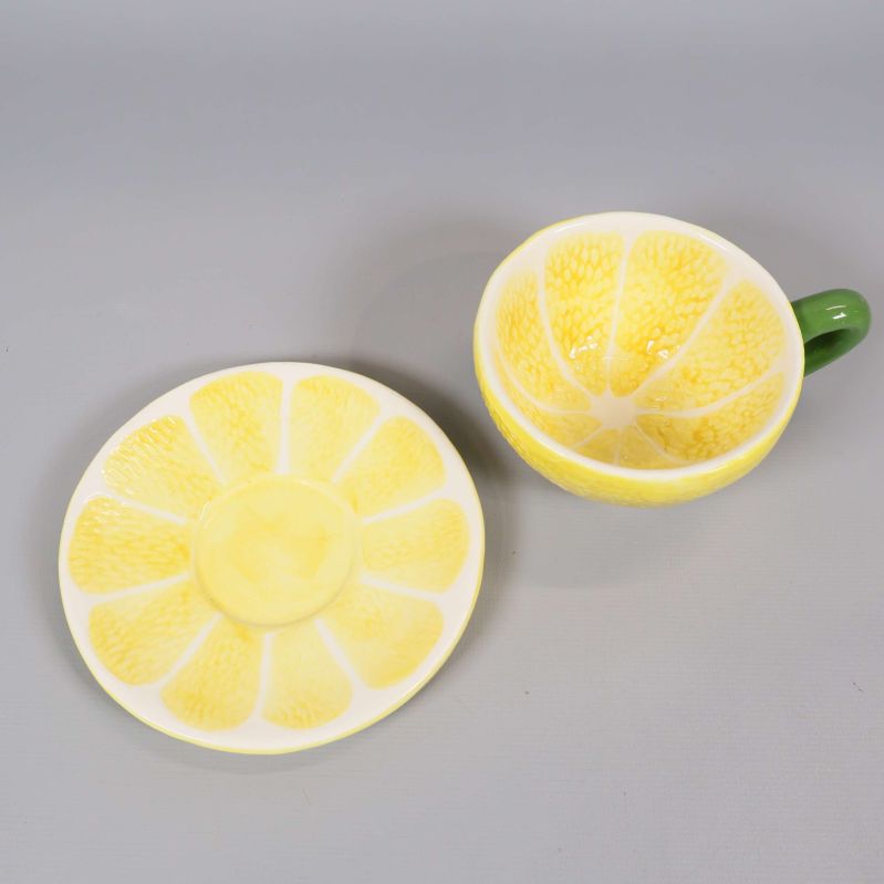 Kopp och fat i gult, båda med citronskivemönster uppifrån