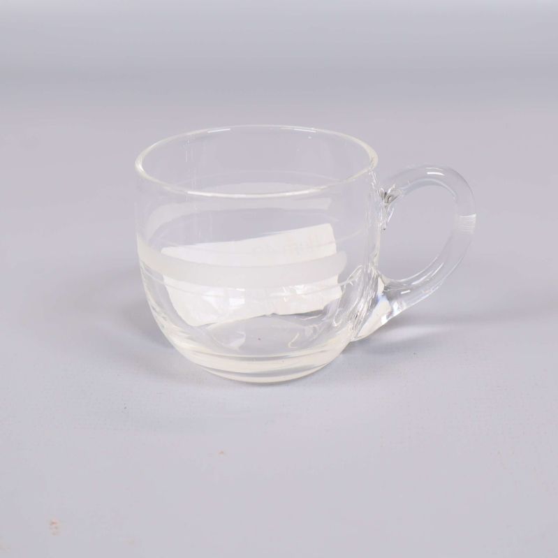 En liten genomskinlig kopp i glas med handtag