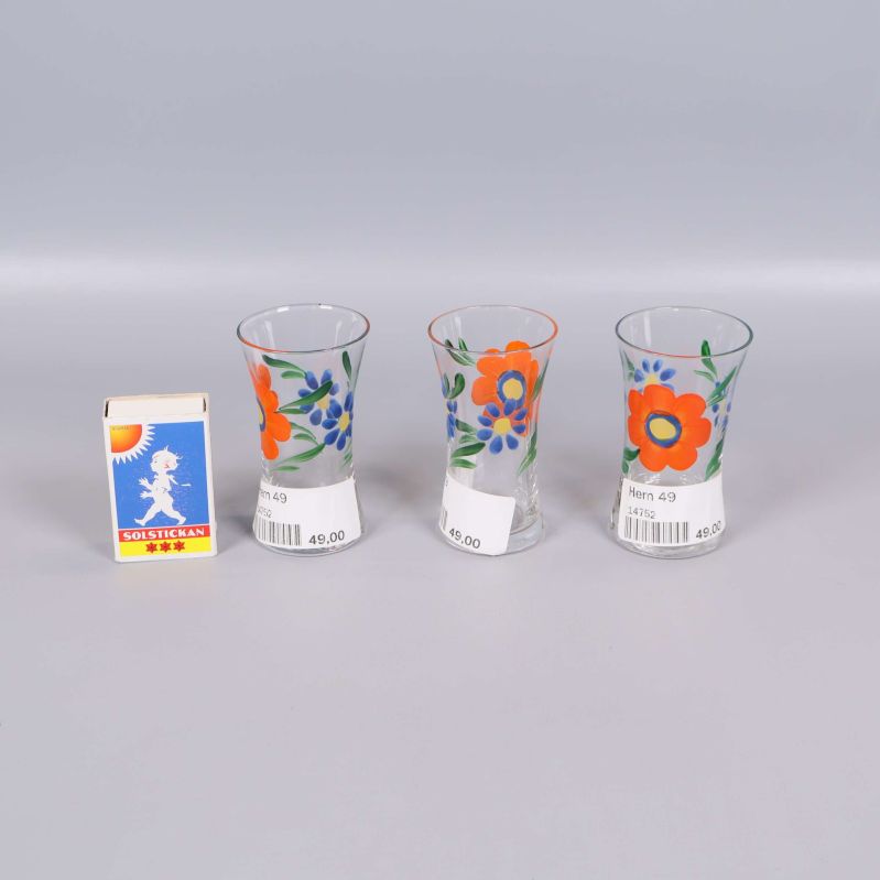 Tre glas med blommönster står intill en tändsticksask