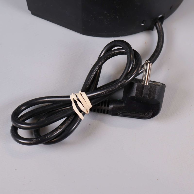 Närbild på svart elkabel med stickkontakt till kaffebryggare