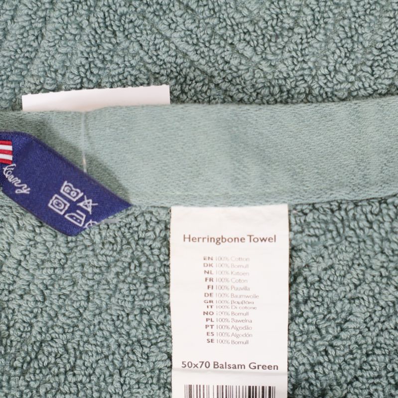 Närbild på material- och tvättrådsetikett på grön handduk