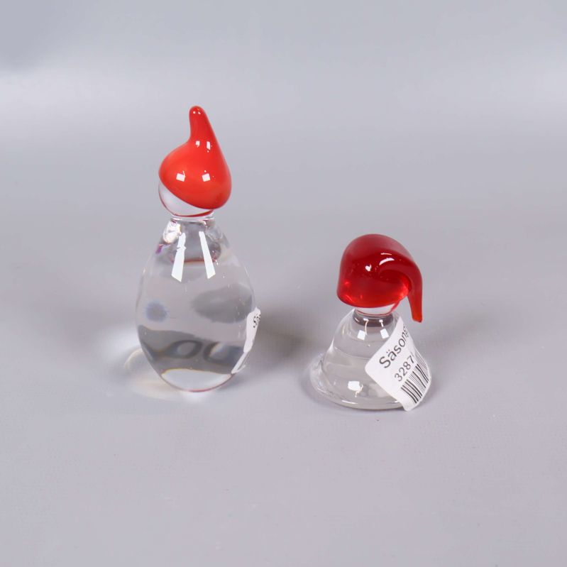 Glasfigurer med röda luvor fotade bakifrån