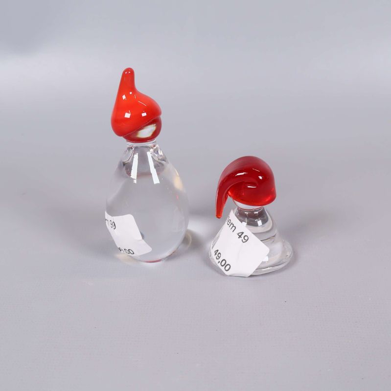 Närbild på glasfigurerna med röda luvor