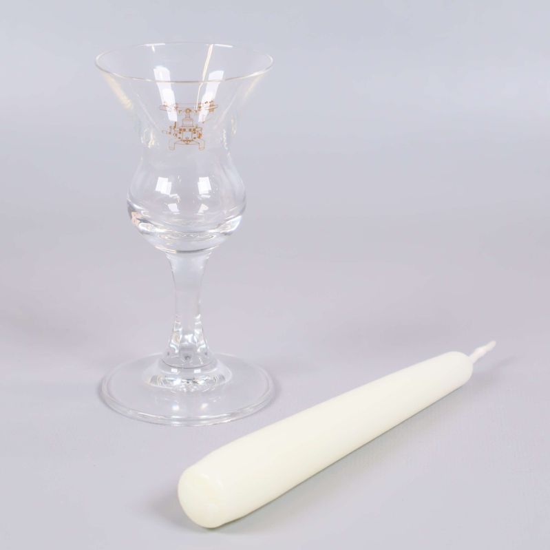 Glas med gulddetalj och ljus utanför förpackning