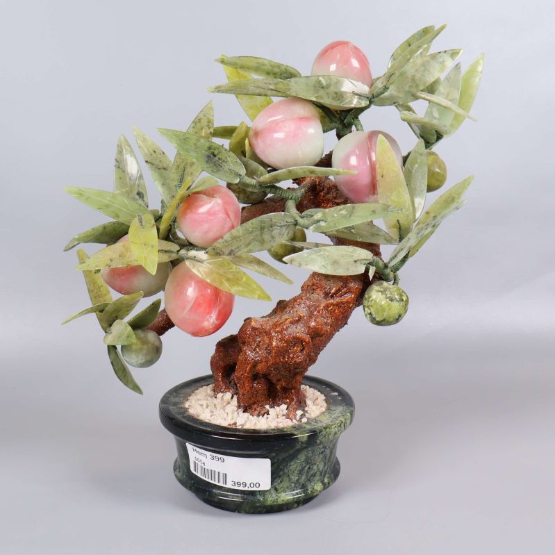 Stenkrukväxt med gröna blad och rosa frukter i marmorfot