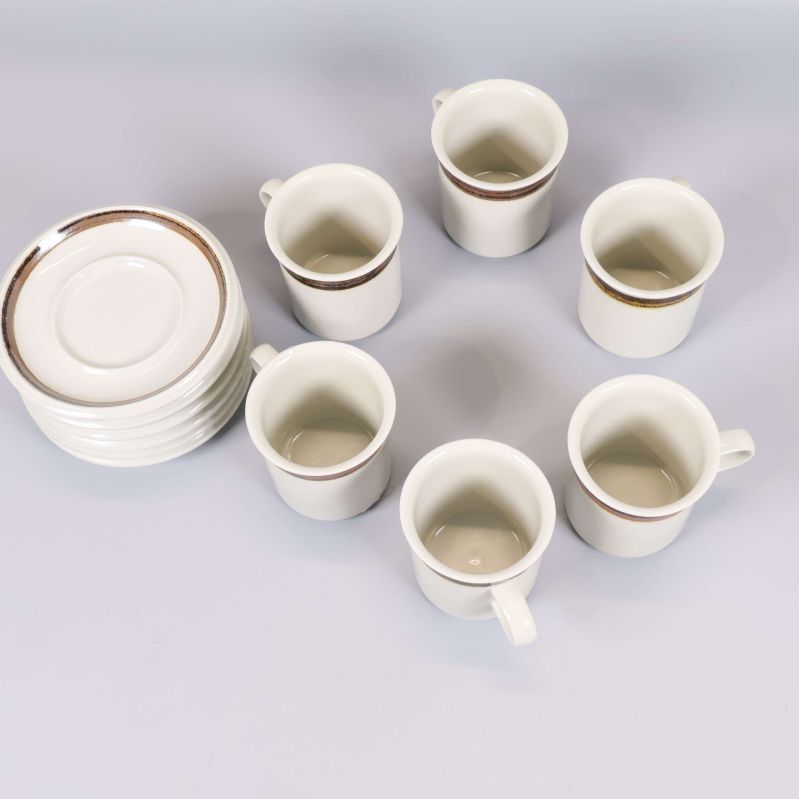 Vy uppifrån på sex kaffekoppar och sex staplade fat