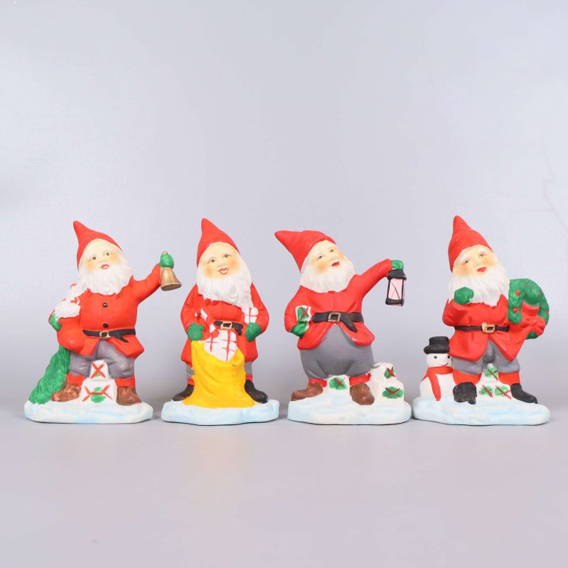Fyra tomtefigurer med julmotiv på rad