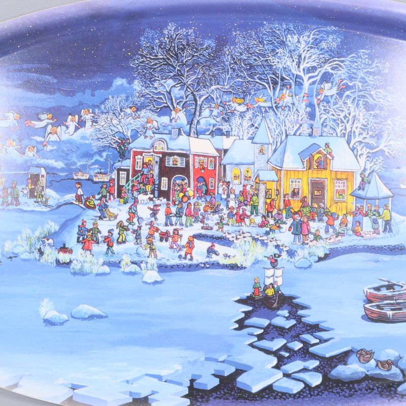 Närbild på julmotiv med snö och hus på brickan