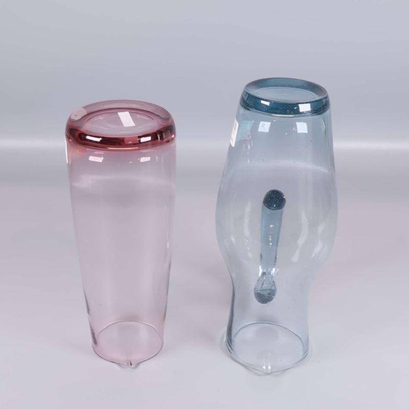 Undersidan av båda kannorna i rosa och blått glas