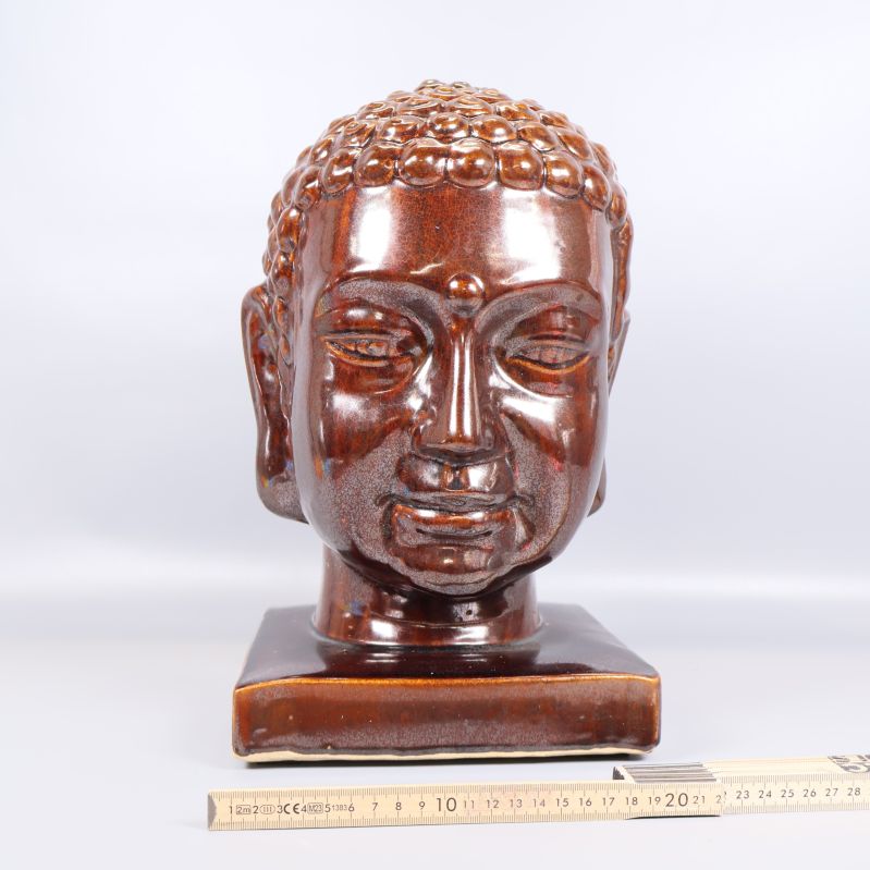 Buddha huvudskulptur med måttstock vid basen