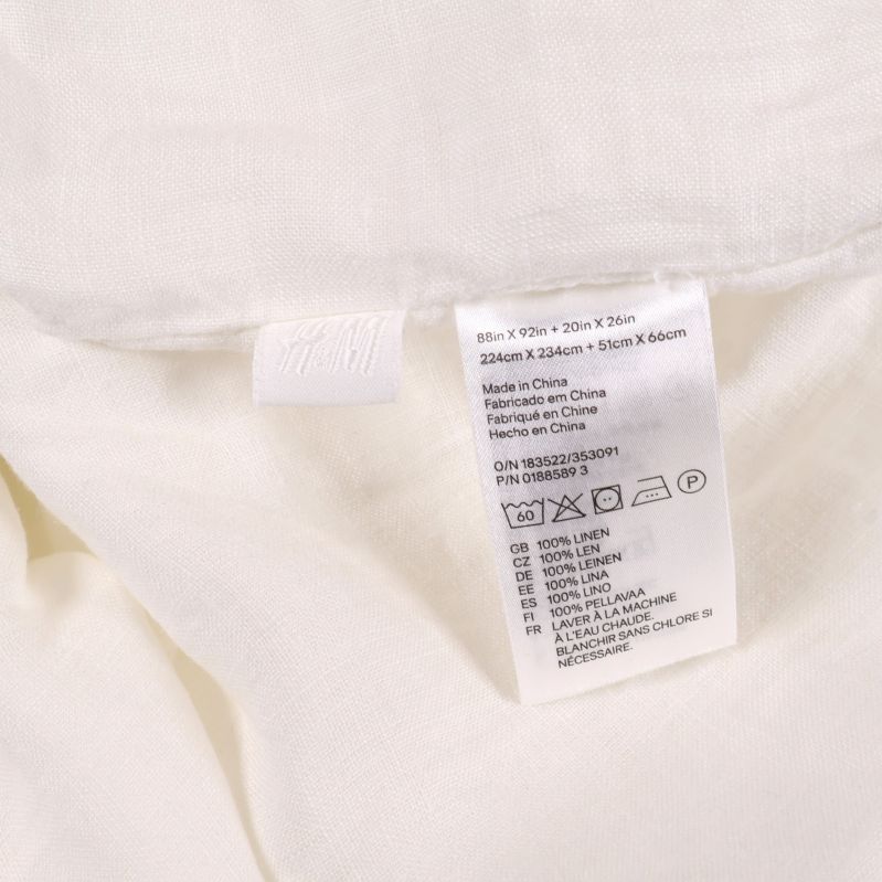 Närbild av linne påslakans materialetikett och quiltade tyg